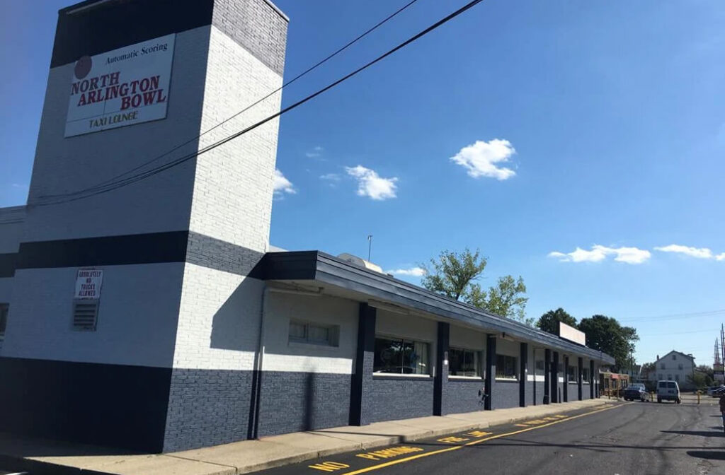 Commercial bowling alley exterior with a white, dark gray and black painted facade.