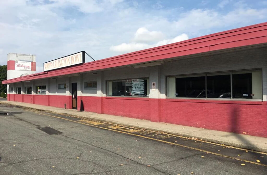 Commercial bowling alley exterior with a red and light gray painted facade.